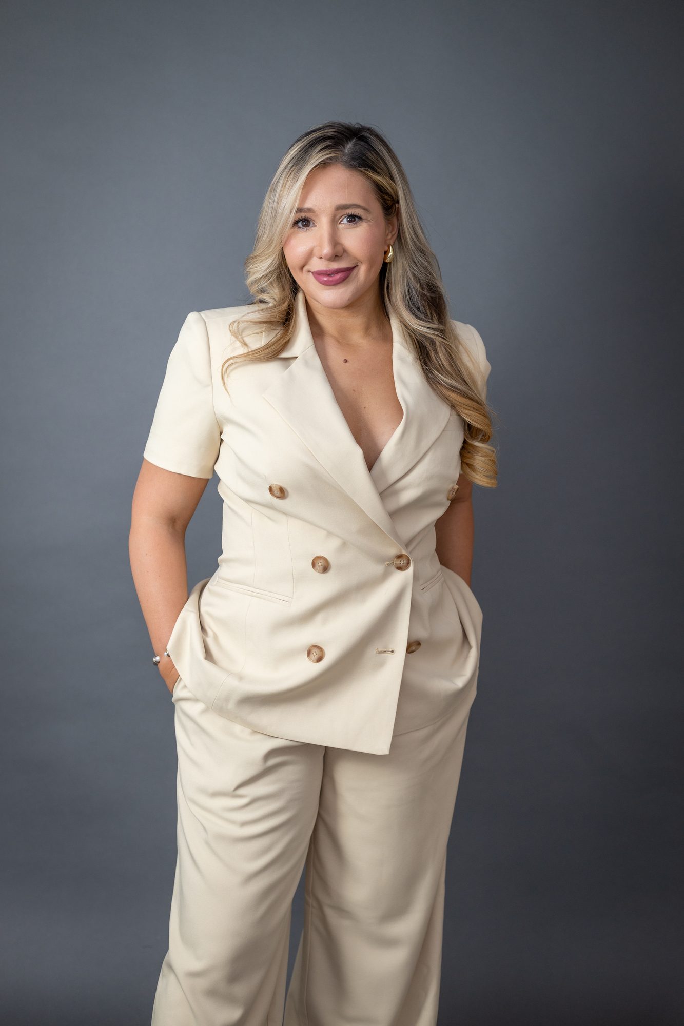 Laura Davis, cream suit studio portrait.